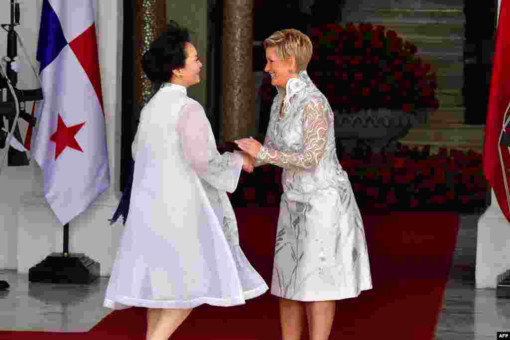 China&#39;s First Lady Peng Liyuan (L) is welcomed by Panama&#39;s First Lady Lorena Castillo, as their husbands hold a meeting, at the presidential palace in Panama City.