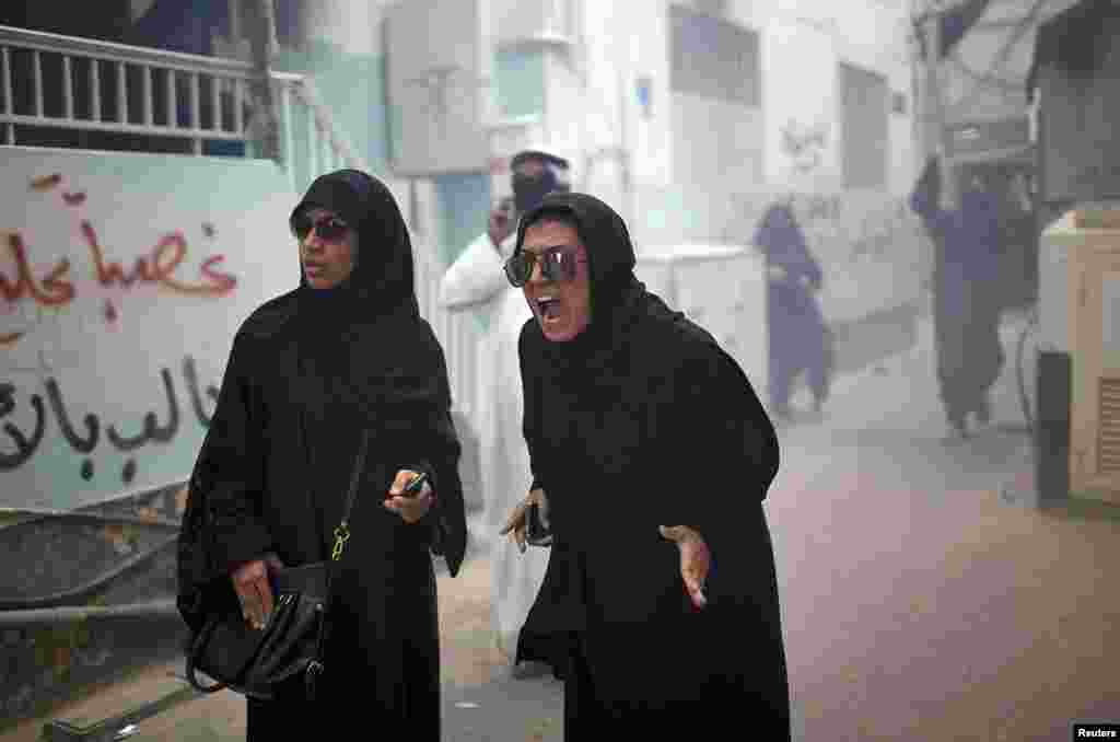 Manifestantes gritan a las autoridades por los gases lacrimógenos con los que intentan controlar las revueltas en Manama.