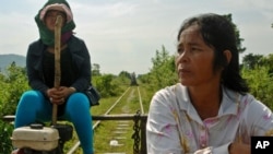 Riding the rails in western Cambodia: The driver of a "flying carpet" and her passenger head west towards the town of Pursat in central Cambodia along the buckled line in late October, closely followed by another flying carpet. This line will be upgraded 