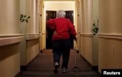 Inez Willis, a senior citizen, walks down the hallway with the aide of a cane to visit a neighbor at her independent living complex in Silver Spring, Maryland April 11, 2012. REUTERS/Gary Cameron (UNITED STATES - Tags: SOCIETY HEALTH) - RTR30N4P