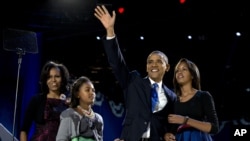 Presiden Barack Obama melambaikan tangan kepada para pendukungnya saat berada di panggung bersama ibu negara, Michelle Obama dan kedua putrinya, Malia dan Sasha untuk memberikan sambutan kemenangan di Chicago, (7/11). 