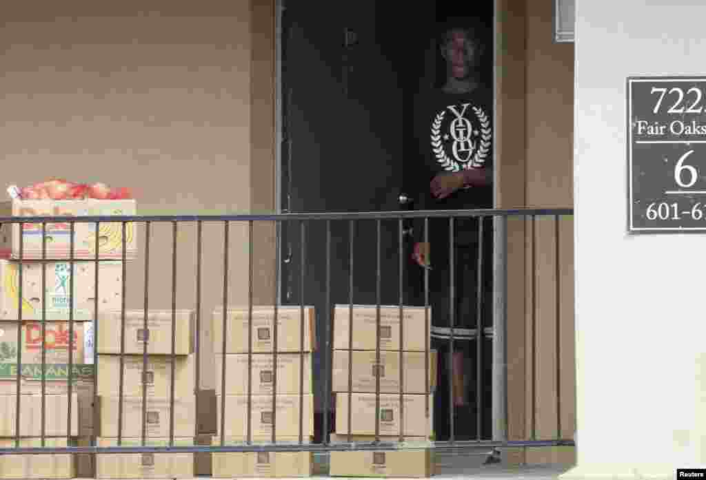 Un homme sort de la résidence de la famille mise en quarantaine pour récupérer les cartons de produits alimentaires que la Croix Rouge a déposés devant l&rsquo;appartement où habitait le malade atteint d&rsquo;Ebola, à Dallas, le 3 octobre 3014. 