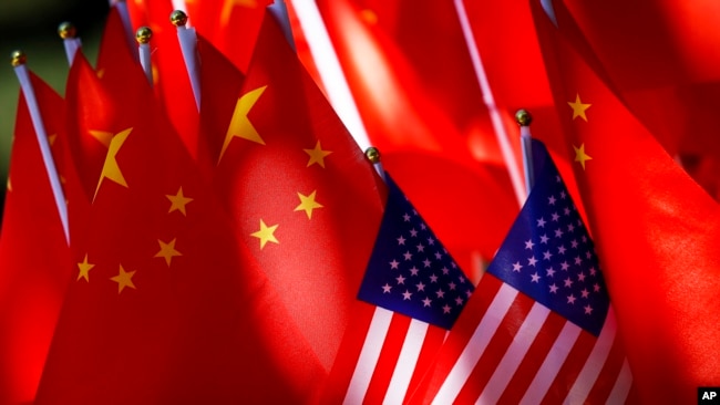 美中贸易关系紧张之际北京街头一辆三轮车上展示的美中两国国旗。（2018年9月16日）