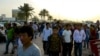 FILE - Migrant workers walk on the corniche in Doha, Qatar April 14, 2017. 