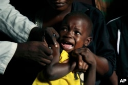 FILE - A boy reacts as he receives a yellow fever vaccine injection in the Kisenso district of Kinshasa, Congo, July 21, 2016.