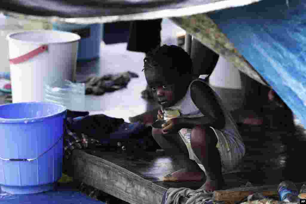 A migrant child peeks out of a tent at a camp in Lajas Blancas, Darien province, Panama.
