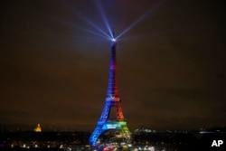 FILE - The Eiffel Tower is lit with colors for the Paris 2024 bid during the launch of the international campaign of the French capital as candidate for the 2024 Olympic summer games, in Paris, France, Feb. 3, 2017.