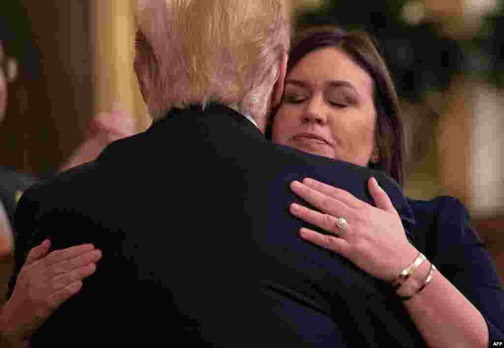 Outgoing White House Press Secretary Sarah Huckabee Sanders hugs US President Donald Trump during an event in the East Room of the White House in Washington, DC, June 13, 2019.