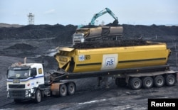 FILE - Heavy equipment is seen loading coal onto a truck at PT Adaro Indonesia coal mining in Tabalong, Kalimantan island, Indonesia Oct. 17, 2017.