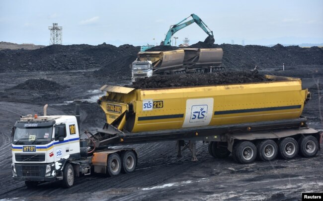 FILE - Heavy equipment is seen loading coal onto a truck at PT Adaro Indonesia coal mining in Tabalong, Kalimantan island, Indonesia Oct. 17, 2017.