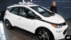 FILE - General Motors Chairman and Chief Executive Officer Mary Barra stands next to an autonomous Chevrolet Bolt electric car, Dec. 15, 2016, in Detroit.