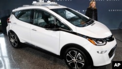 FILE - General Motors Chairman and Chief Executive Officer Mary Barra stands next to an autonomous Chevrolet Bolt electric car, Dec. 15, 2016, in Detroit.