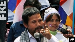An activist of Cambodian National Rescue Party Meach Sovannara, left, gives a speech at a blocked main street near the Phnom Penh Municipality Court during a gathering to call for the release of anti-government protesters who were arrested in a police cra