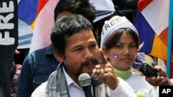 An activist of Cambodian National Rescue Party Meach Sovannara, left, gives a speech at a blocked main street near the Phnom Penh Municipality Court during a gathering to call for the release of anti-government protesters who were arrested in a police crackdown, in Phnom Penh, Cambodia, Tuesday, May 20, 2014. Nearly two dozen of Cambodia's anti-government protesters were arrested earlier this year in connection with social unrest. (AP Photo/Heng Sinith)