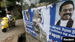 A woman rides her bike past the election posters of Sri Lanka's former Sri Lankan President Mahinda Rajapaksa for upcoming general election in Colombo, July 14, 2015.