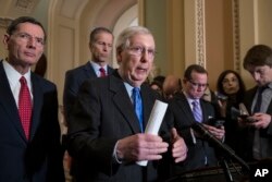 FILE - Senate Majority Leader Mitch McConnell, R-Ky., center, speaks to reporters about the possibility of a partial government shutdown, at the Capitol in Washington, Dec. 18, 2018.