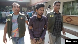 Police officers in Dhaka detain Nahid Hasan, a member of Jamaat-e-Islami, Bangladesh's biggest religion-based party, on suspicion he was involved in Islamic State propaganda, Nov. 25, 2015.