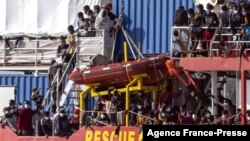 Migrants rescued in the Mediterranean sea arrive to disembark from the Sea-Eye 4 ship, Nov. 7, 2021, in the port of Trapani, Sicily, Italy. 