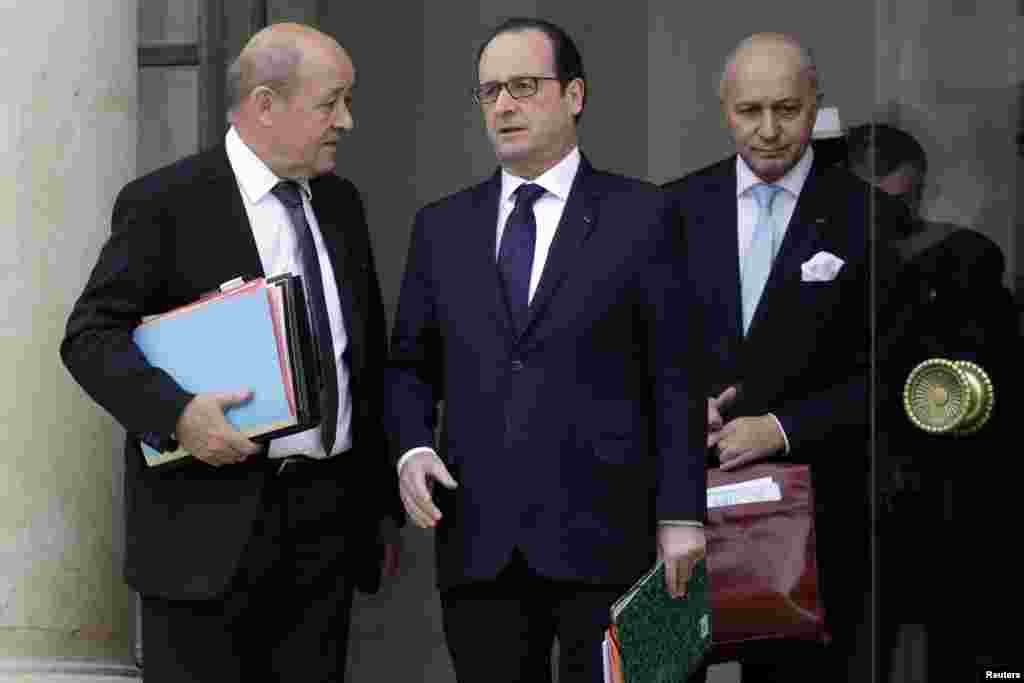 French President Francois Hollande, center, speaks with Defense Minister Jean-Yves Le Drian, left, and Foreign Affairs Minister Laurent Fabius at the end of a defense council at the Elysee Palace in Paris, Jan. 21, 2015.