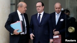 French President Francois Hollande, center, speaks with Defense Minister Jean-Yves Le Drian, left, and Foreign Affairs Minister Laurent Fabius at the end of a defense council at the Elysee Palace in Paris, Jan. 21, 2015.