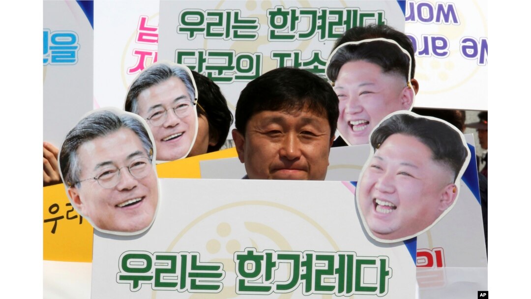 Aktivisti sa maskama sa likovima južnokorejskog predsednika Mun Đae Ina, levo, i severnokorejskog lidera Kim Džong Una na mitingu podrške planiranom samitu Juga i Severa u Seulu, Južna Koreja, 25. aprila 2018.