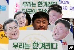 Aktivisti sa maskama sa likovima južnokorejskog predsednika Mun Đae Ina, levo, i severnokorejskog lidera Kim Džong Una na mitingu podrške planiranom samitu Juga i Severa u Seulu, Južna Koreja, 25. aprila 2018.