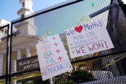 Poster-poster yang menggambarkan hasil pilpres tergantung di luar gereja St. John dekat Gedung Putih setelah mantan wakil presiden Joe Biden diproyeksikan memenangi pilpres, di Washington, Minggu, 8 November 2020. (Foto: Reuters)