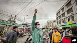 Para pengunjuk rasa turun ke jalan dalam aksi demo anti pemerintah di Mandalay, Myanmar, pada 7 Desember 2021. Demo tersebut terjadi sehari setelah tokoh politik Aung San Suu Kyi dijatuhi hukuman. (Foto: AP)
