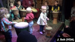 Children move to the rhythm of Baba Ras D's beat at the Harambee program in Washington.