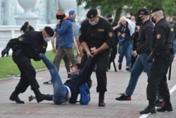 FILE - Belarus' security service agents and riot police officers detain an opposition supporter in Minsk on July 14, 2020, after the country's central electoral commission refused to register the main rivals to President Alexander Lukashenko as candidates for the country's presidential election in August.