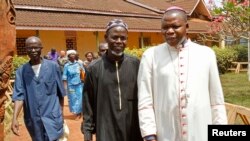 FILE - Archbishop of Bangui Dieudonne Nzapalainga (R) walks with imam Oumar Kobine Layama (2nd R), representative of the local Muslim community, in Bangui Feb. 10, 2014.