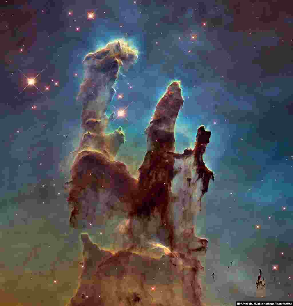 &laquo;Столпы Творения&raquo;, 5 января 2015 Это самый известный снимок туманности Орел и одна из наиболее красочных фотографий, на которой изображены скопления межзвездного газа и космической пыли. Впервые они были зафиксированы телескопом &laquo;Хаббл&raquo; в 1995 году, а спустя 20 лет космический телескоп повторил легендарный снимок в честь своего 25-летия (именно этот снимок вы видите). Свое название - &laquo;Столпы Творения&raquo; - они получили из-за того, что в этих объектах происходит формирование новых звезд. 📸: NASA, ESA/Hubble, Hubble Heritage Team via AP