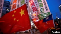 FILE - Members of a Taiwanese independence group march with flags around the group of pro-China supporters holding a rally calling peaceful reunification, days before the inauguration ceremony of President-elect Tsai Ing-wen, in Taipei, Taiwan May 14, 2016.