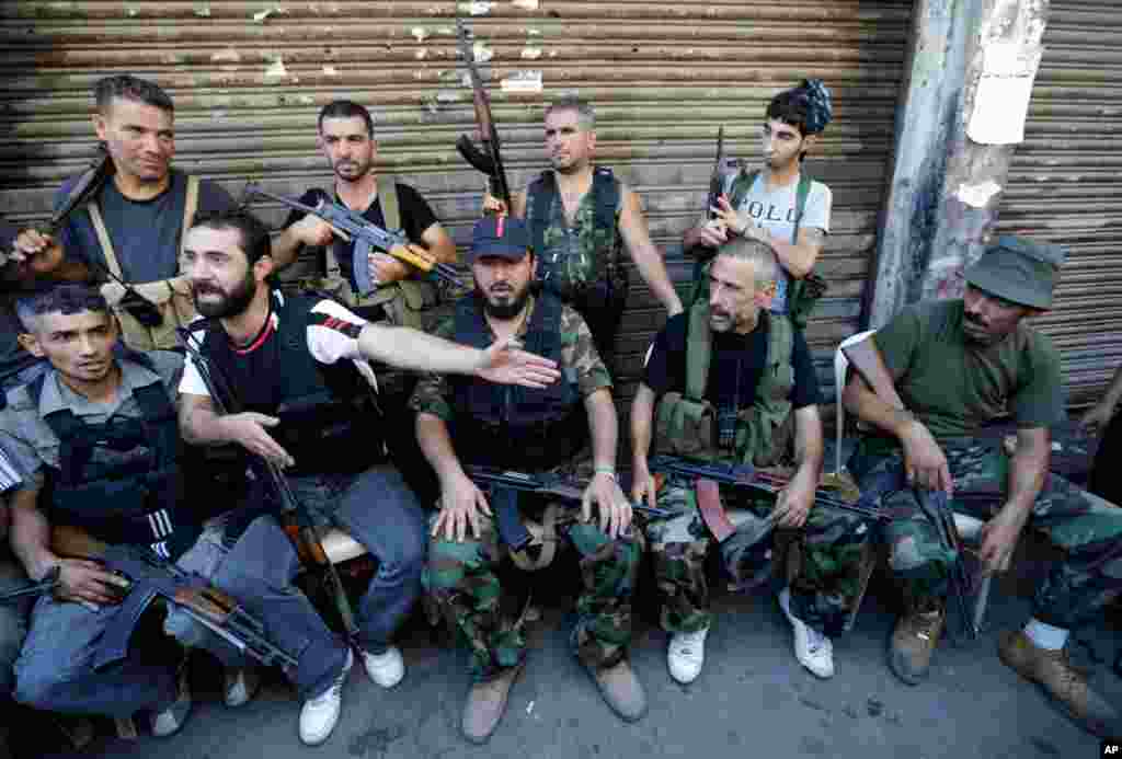 C&aacute;c tay s&uacute;ng Hồi gi&aacute;o Sunny ngồi ở một con đường ở Tripoli, Liban nơi đ&atilde; nổ ra vụ đụng độ giữa nh&oacute;m ủng hộ v&agrave; nh&oacute;m chống đối chế độ Syria, 22/8/12 
