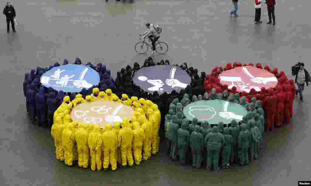 Olympic rings are displayed in Paris, France, with images against restriction of speech and freedom of information, repression of demonstrations, discrimination due to sexual orientation and migrant&#39;s exploitation, as part of a protest by human rights organizations a week before of the Sochi Winter Olympic Games.