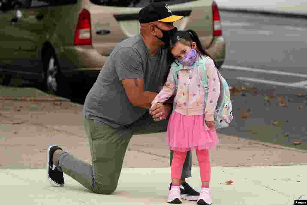 Joel Balcita comforts his daughter Sadie just before she starts her first day of grade 1 at P.S. 130 in the Brooklyn borough of New York City.