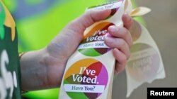 A woman holds stickers as Ireland holds a referendum on liberalizing abortion laws, in Dublin, May 25, 2018. 