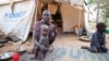 A woman and her children displaced by fighting in South Sudan sit outside their tent at the Kule camp for Internally Displaced People at the Pagak border crossing in Gambella, Ethiopia, July 10, 2014.