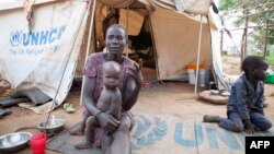 FILE - A woman and her children displaced by fighting in South Sudan sit outside her tent at the Kule camp for Internally Displaced People at the Pagak border crossing in Gambella, Ethiopia, July 10, 2014.