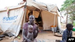 FILE - A woman and her children displaced by fighting in South Sudan sit outside her tent at the Kule camp for Internally Displaced People at the Pagak border crossing in Gambella, Ethiopia.