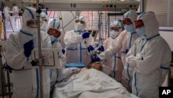 A patient infected with COVID-19 is treated in one of the intensive care units (ICU) at the Severo Ochoa hospital in Leganes, outskirts of Madrid, Spain, Friday, Oct. 9, 2020. 