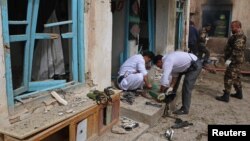Para petugas Afghanistan memeriksa tempat terjadinya serangan bom buni diri di luar masjid Syiah di Herat, Afghanistan, 25 Maret 2018 (foto: REUTERS/Mohammad Shoib)