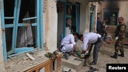 Afghan officials inspect the site of a suicide bomb attack outside a Shi'ite mosque in Herat, Afghanistan, March 25, 2018. 