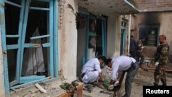 아프간 당국자들이 25일 헤라트 사원 밖에서 자살폭탄 공격 현장을 조사하고 있다.