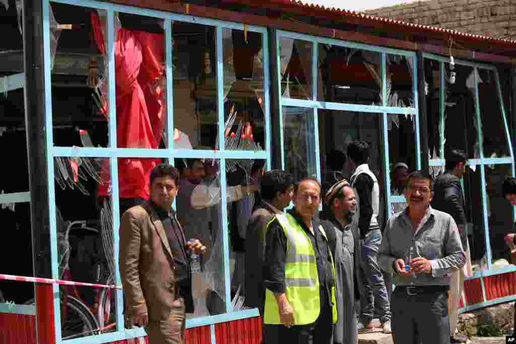 Civilians and security forces inspect the site of a suicide attack in Kabul, May 4, 2015.