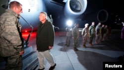 U.S. Secretary of Defense Chuck Hagel prepares to step aboard a C-17 military aircraft en route to Kabul, Afghanistan, after greeting U.S. troops (R ) stationed at Manas Air Force Base in Kyrgyzstan, March 8, 2013.