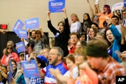 Supporters of Democratic presidential candidate Bernie Sanders celebrate their win over Hillary Clinton at a Democratic caucus at Bryan High School in Bellevue, Neb., March 5, 2016.