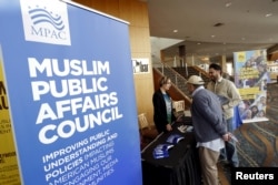 FILE - People stand at the registration desk for a Muslim Public Affairs Council convention in Long Beach, Calif., Dec. 5, 2015.