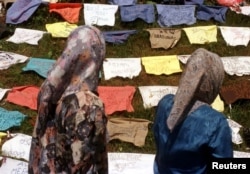 FILE - Refugee women read the names of missing men written on pillows July 18 at the site near the Bosnian town of Kladanj where Muslims from Srebrenica crossed the former front line three years ago escaping from Bosnian Serb forces, July 11, 1995.