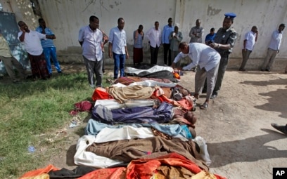 Somalis look at bodies of civilians displayed in the capital Mogadishu, Somalia, Aug. 25, 2017, following a botched joint U.S.-Somali raid.